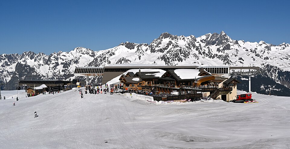 Gares des remontées (téléphérique des Grandes Rousses, télémix des Jeux) et front de neige aux Jeux 2100, avril 2026 (5456x2804 ; vignette 960px : https://uploa