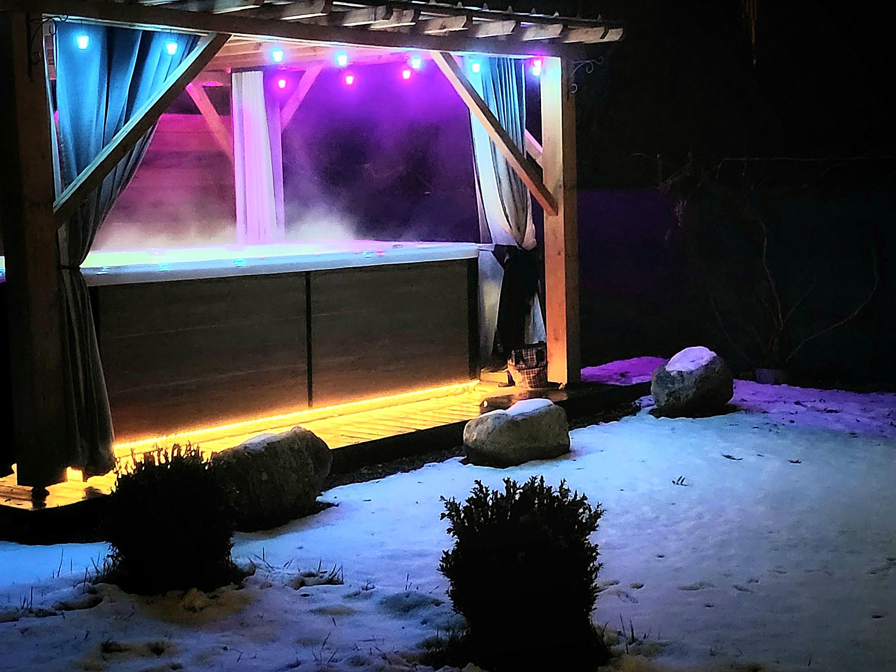 Le spa de nage éclairé la nuit, jardin sous la neige